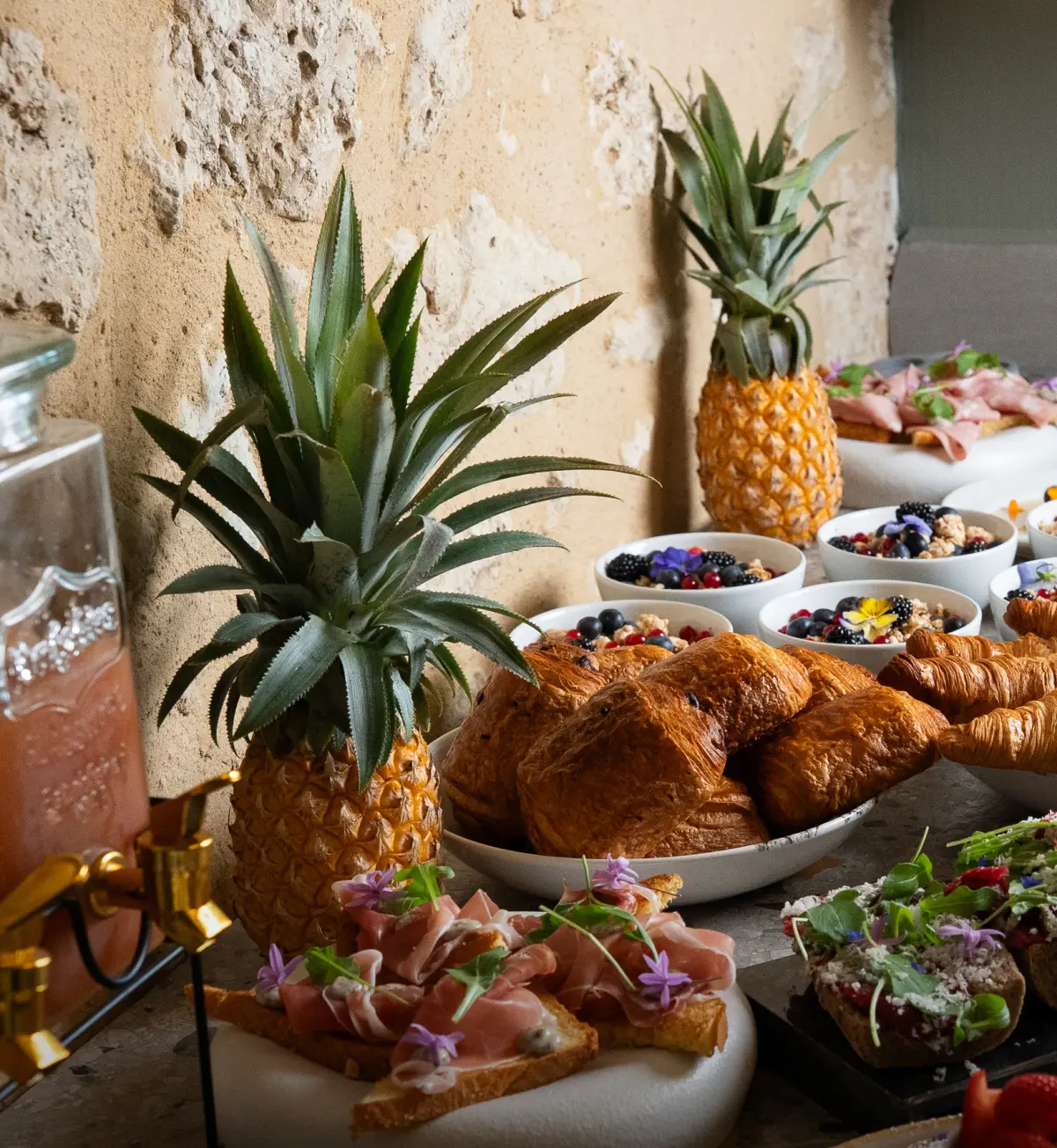 De brunchtafel met croissants, ananassen en vers fruit